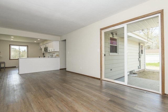 unfurnished living room featuring visible vents, recessed lighting, dark wood finished floors, and baseboards