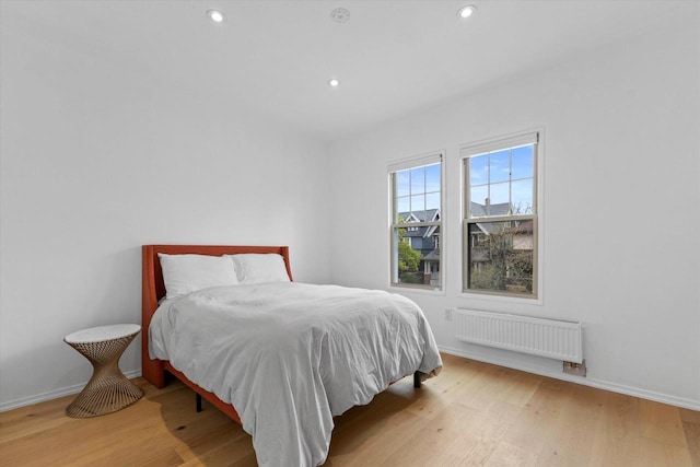 2627 N Farwell Ave, Milwaukee, WI 53211 - bedroom with radiator, wood finished floors, baseboards, and recessed lighting