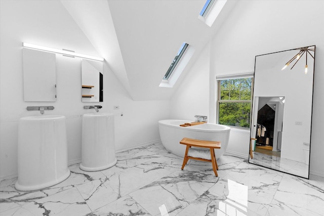 2627 N Farwell Ave, Milwaukee, WI 53211 - bathroom with marble finish flooring, a skylight, a soaking tub, and baseboards