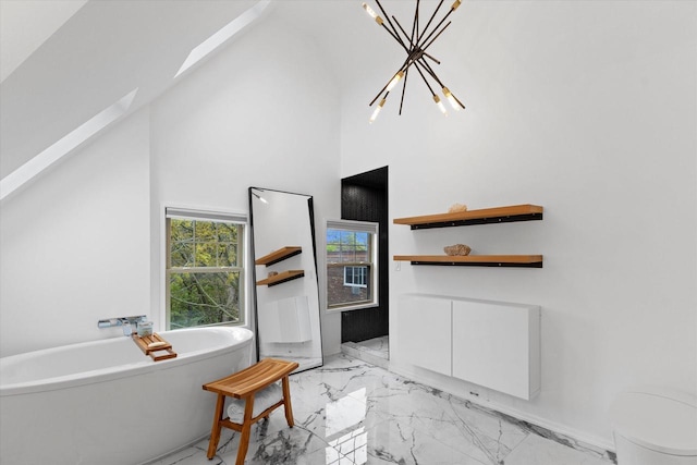 2627 N Farwell Ave, Milwaukee, WI 53211 - full bathroom with marble tiled floors, a chandelier, a freestanding tub, a high ceiling, and a skylight
