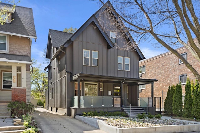 2627 N Farwell Ave, Milwaukee, WI 53211 - view of front facade with covered porch, board and batten siding, concrete driveway, and a shingled roof