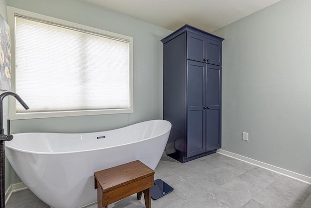 bathroom with baseboards and a freestanding bath