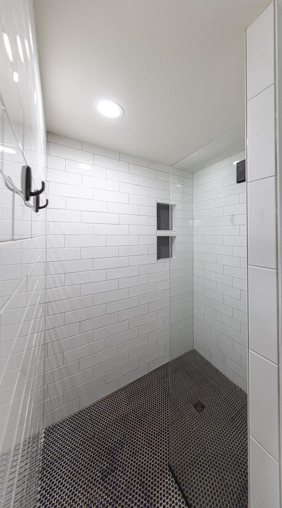 full bath featuring a tile shower and recessed lighting