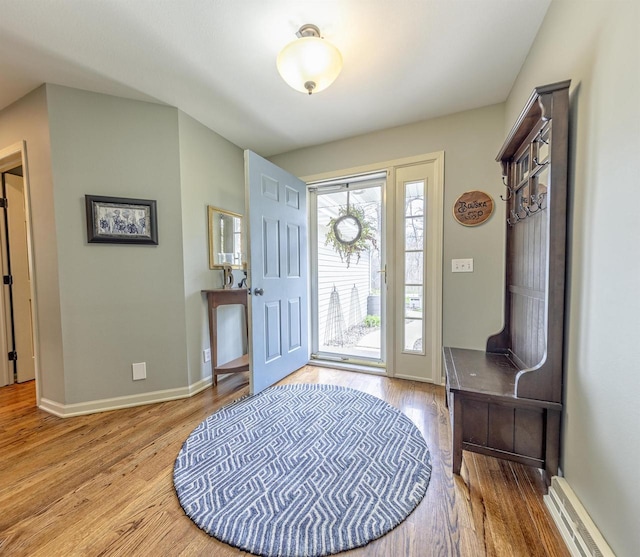 entryway with baseboards, a baseboard heating unit, and wood finished floors