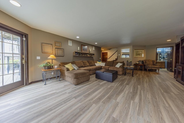 living room featuring light wood-type flooring, recessed lighting, stairs, and baseboards