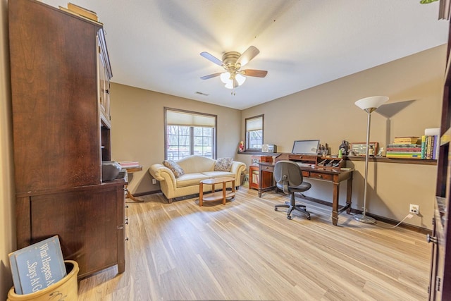 office area with baseboards, ceiling fan, and light wood-style flooring