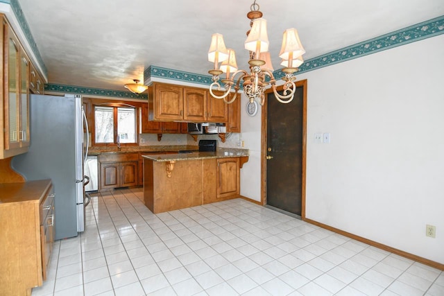 kitchen featuring brown cabinets, a notable chandelier, stainless steel appliances, a peninsula, and a kitchen bar