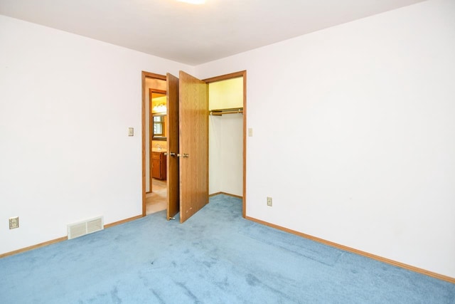 unfurnished bedroom featuring baseboards, visible vents, carpet, and a closet