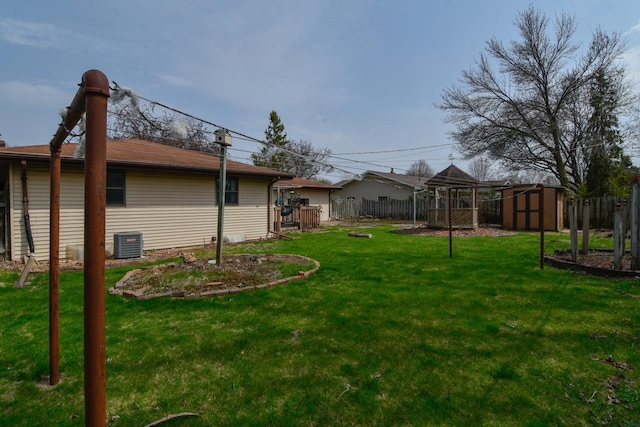view of yard with central air condition unit, an outdoor structure, a storage shed, and a fenced backyard