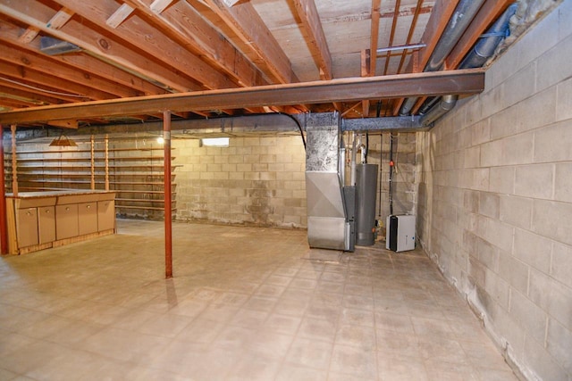 unfinished below grade area featuring heating unit, tile patterned floors, and gas water heater