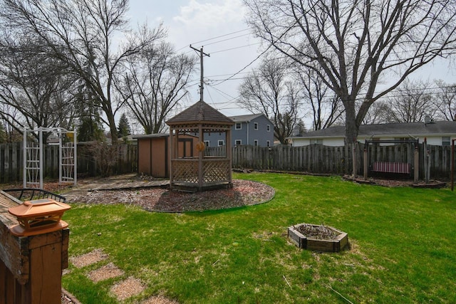 view of yard with a fenced backyard, a gazebo, and a shed