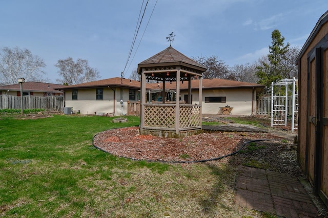 rear view of house with a gazebo, a lawn, fence, and cooling unit