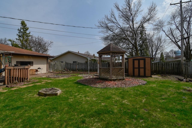 view of yard featuring a gazebo, an outbuilding, a shed, and a fenced backyard
