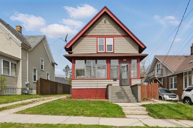 view of front of property with a front lawn and fence