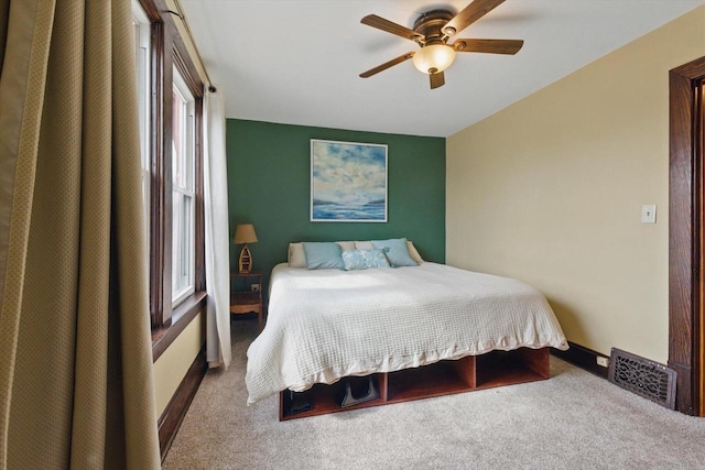 carpeted bedroom with ceiling fan and visible vents