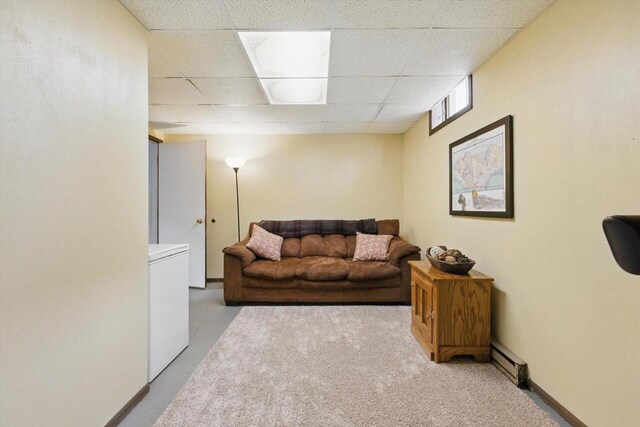 living area featuring carpet floors, washer / dryer, a drop ceiling, and a baseboard radiator