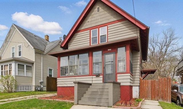 bungalow-style house featuring fence and a front yard