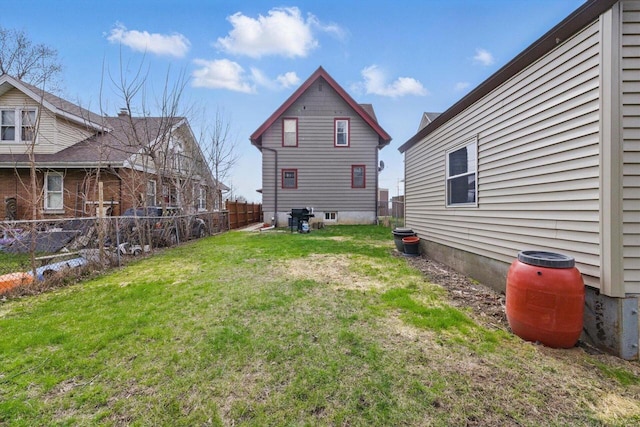 back of house featuring a fenced backyard and a yard