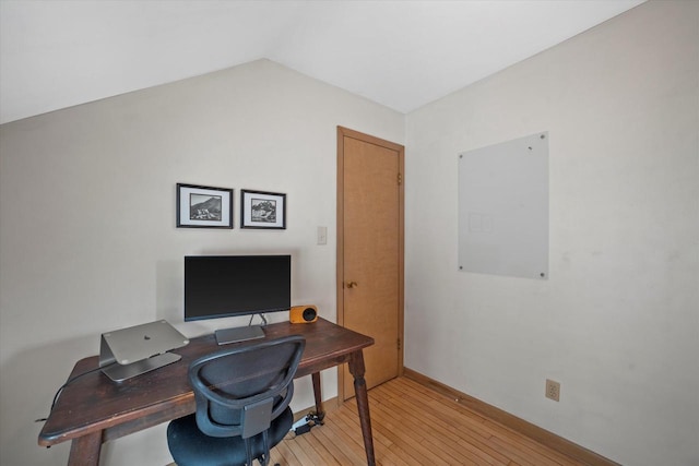 office area featuring light wood-style floors, baseboards, and lofted ceiling