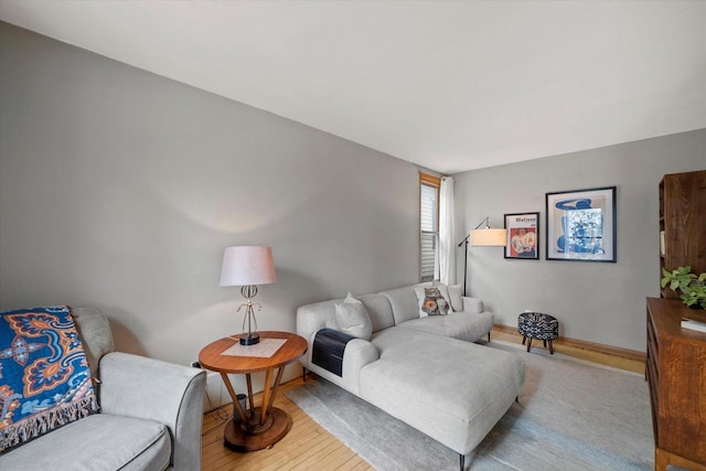 living area with baseboards and wood finished floors