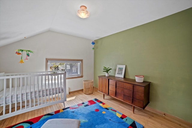 bedroom featuring baseboards, lofted ceiling, and hardwood / wood-style floors