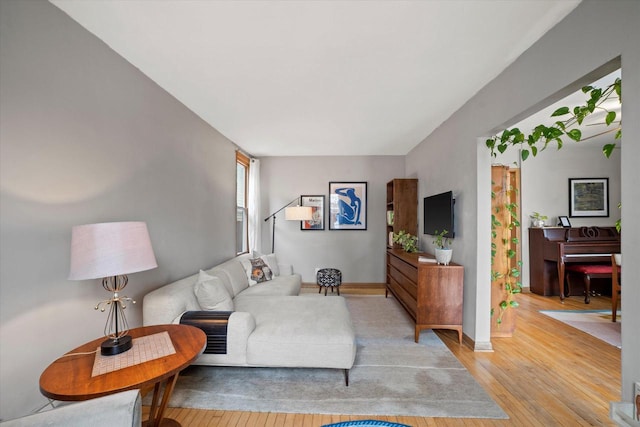 living area featuring baseboards and light wood-style flooring