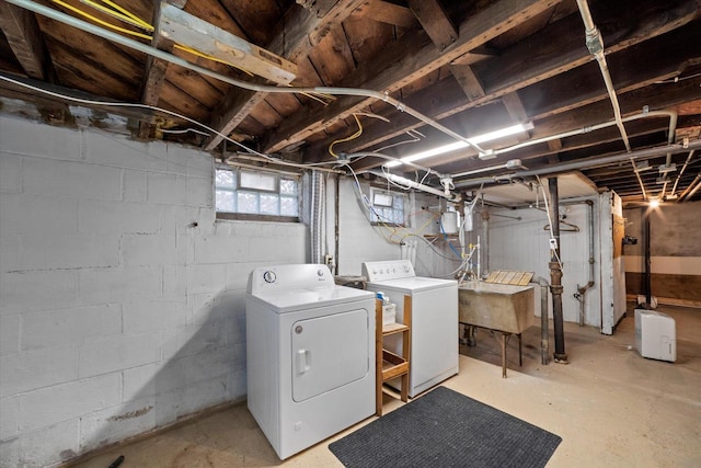 below grade area featuring a sink and washing machine and clothes dryer