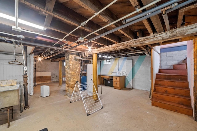 unfinished basement featuring a sink and stairs