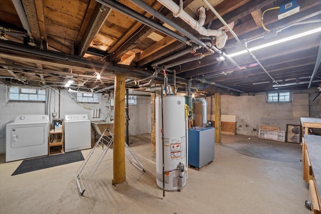 below grade area with a sink, water heater, and independent washer and dryer