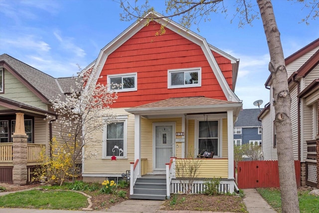 dutch colonial featuring a porch, a gambrel roof, and roof with shingles