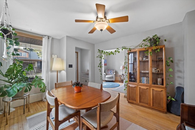 dining area with light wood-style floors and a ceiling fan