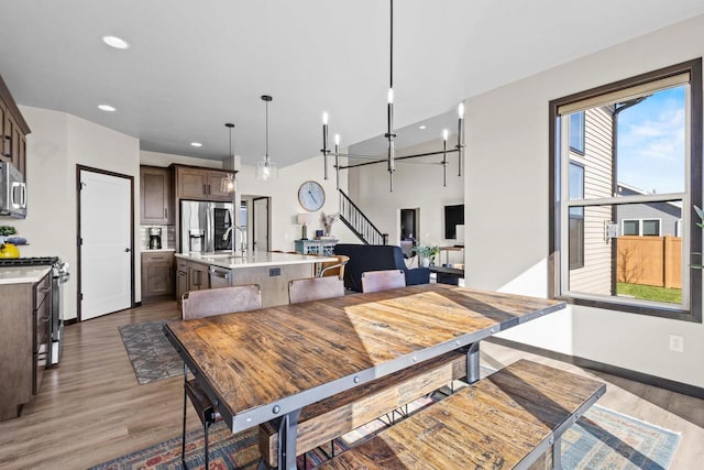 dining area with stairs, recessed lighting, baseboards, and wood finished floors