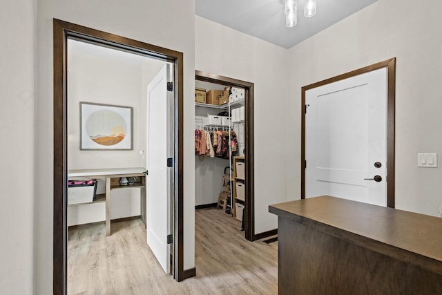 hallway featuring baseboards and light wood-style flooring