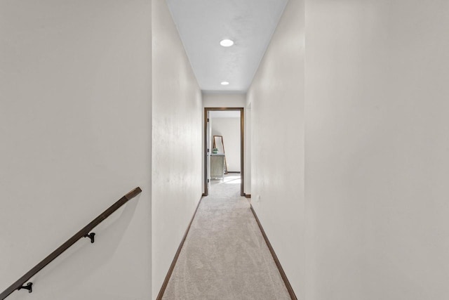 corridor featuring recessed lighting, baseboards, light carpet, and an upstairs landing