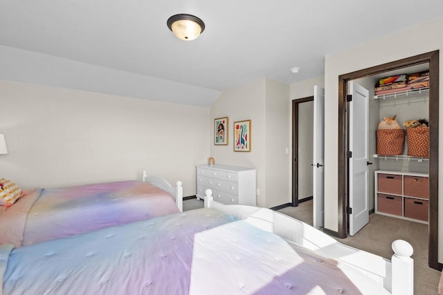 carpeted bedroom featuring baseboards, vaulted ceiling, and a closet