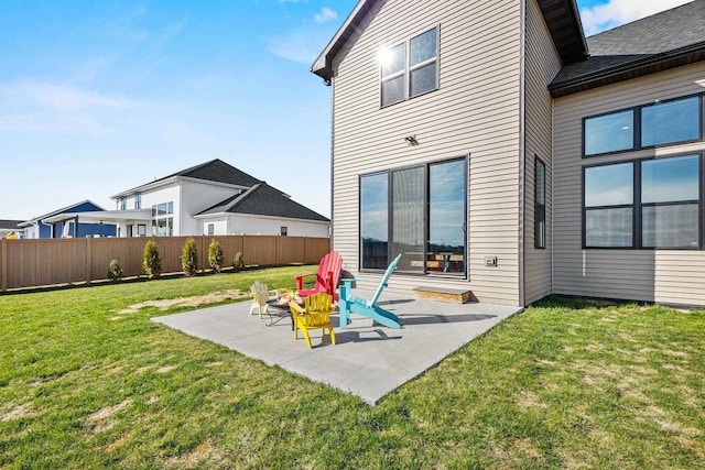 back of property with a lawn, fence, and a patio area