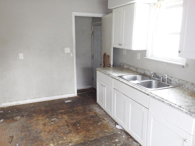 kitchen with a sink, light countertops, and white cabinets