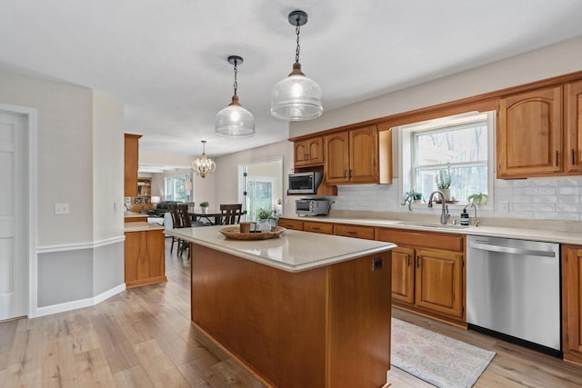 kitchen featuring light countertops, stainless steel appliances, decorative backsplash, and a sink