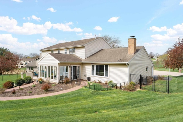 rear view of property featuring a gate, fence, a yard, and a chimney