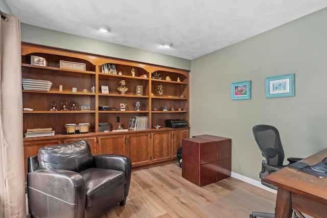 office space with baseboards and light wood-type flooring