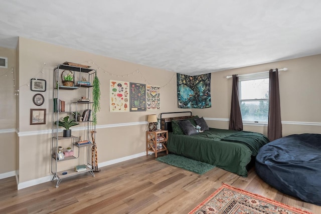 bedroom featuring baseboards and wood finished floors
