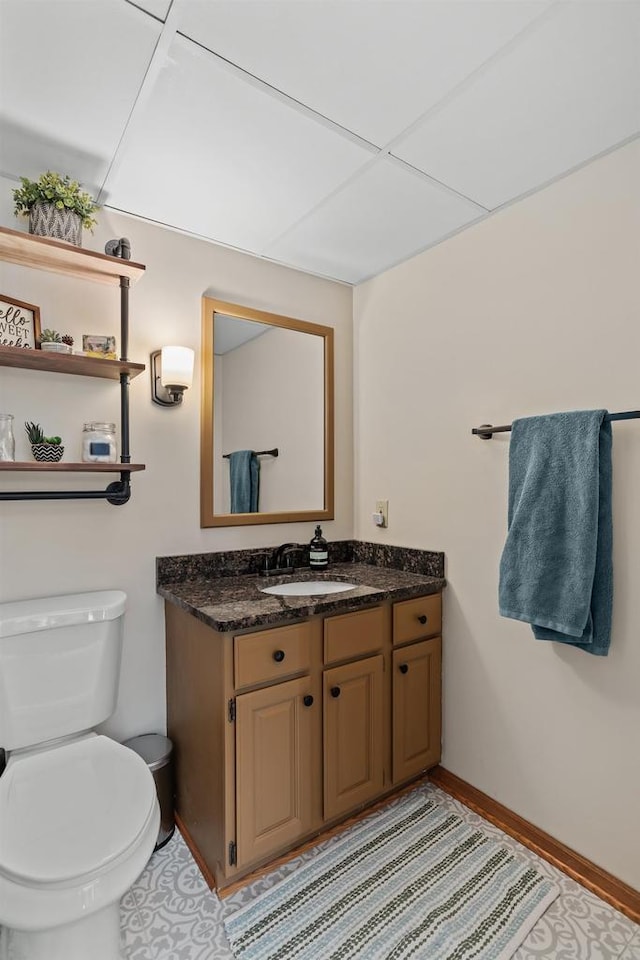 bathroom with baseboards, toilet, and vanity
