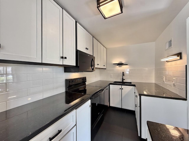 kitchen featuring dark tile patterned floors, white cabinets, tasteful backsplash, a sink, and black appliances