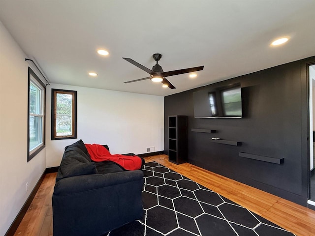 living area featuring recessed lighting, a ceiling fan, baseboards, and wood finished floors