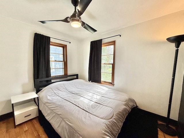 bedroom featuring baseboards, ceiling fan, and wood finished floors