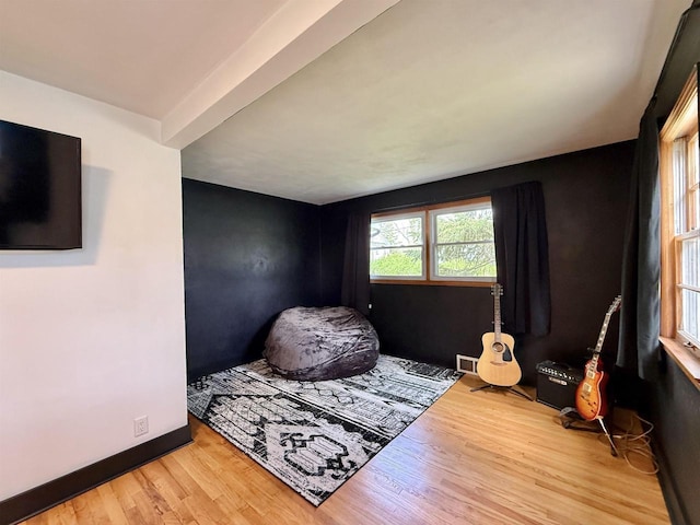 bedroom with baseboards, wood finished floors, and visible vents