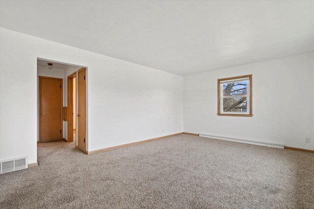 carpeted empty room featuring baseboards, visible vents, and a baseboard radiator