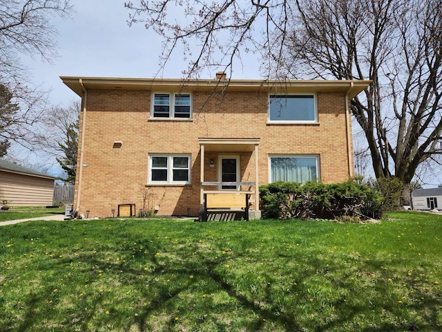view of front of house featuring brick siding and a front yard