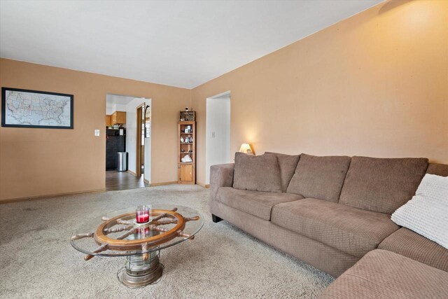 carpeted living area featuring baseboards