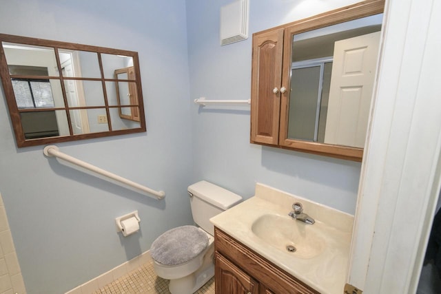 bathroom featuring tile patterned flooring, vanity, toilet, baseboards, and an enclosed shower